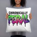 White square throw pillow with "CHRONICALLY" in black block letters and "FERAL" in large bold graffiti lettering with a green-to-purple rainbow gradient, heavy paint drips, and ink splatter. Feral as Fhawk™.